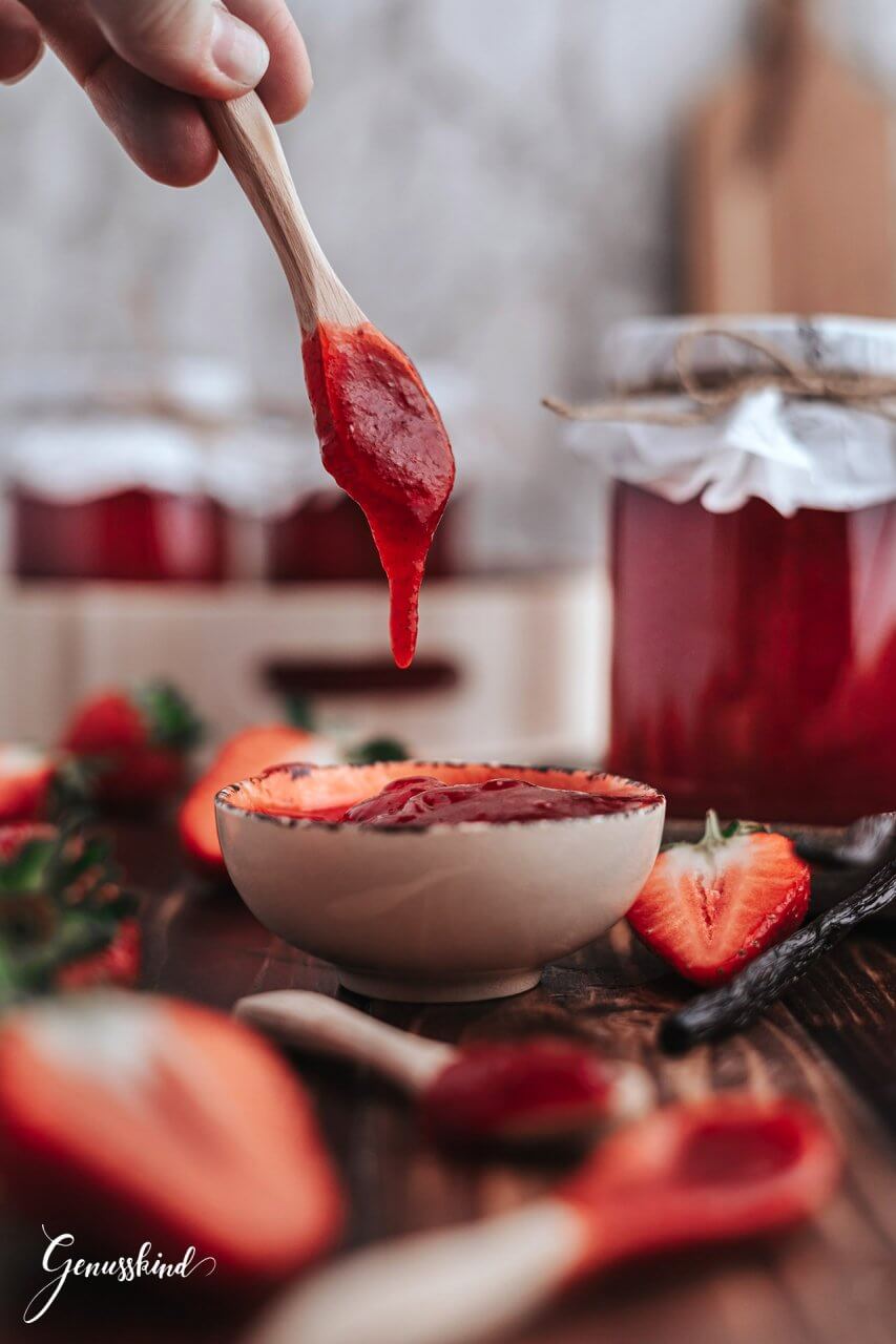 Zubereitung der Erdbeer-Vanille Marmelade Zuerst 3-4 Marmeladegläser à 300 ml mit kochendem Wasser ausspülen, abkühlen und anschließend auf einem sauberen Geschirrtuch trocknen lassen. Die Erdbeeren danach waschen, putzen und vierteln. Die Vanilleschoten der Länge nach halbieren und das Mark vorsichtig mit einem Messer herauskratzen. Anschließend den Gelierzucker, das ausgekratzte Vanillemark, die Schoten, den Vanillezucker und die Erdbeeren in einen Topf geben. Die Zutaten gut miteinander vermischen und anschließend mit einem Stabmixer pürieren. (Wenn die Marmelade stückig werden soll, diesen Schritt einfsch überspringen) Die Erdbeermischung unter ständigem Rühren aufkochen und danach ca. 3-4 Minuten sprudelnd kochen lassen. Die Erdbeer-Vanille Marmelade danach durch ein Sieb streichen und mit einem Trichter in die Gläser bis zum Rand füllen. Wer möchte, kann zuvor noch eine Gelierprobe machen: Dafür einen Löffel der Marmelade auf einen kleinen Teller geben und kurz erkalten lassen. Wenn sie fest wird, ist sie bereit zum Abfüllen. Die Gläser gut verschließen und bei Zimmertemperatur vollständig abkühlen lassen. Jetzt können die Gläser noch mit einem schönen Etikett dekoriert und im Vorratsraum für mindestens 6-12 Monate aufbewahrt werden.